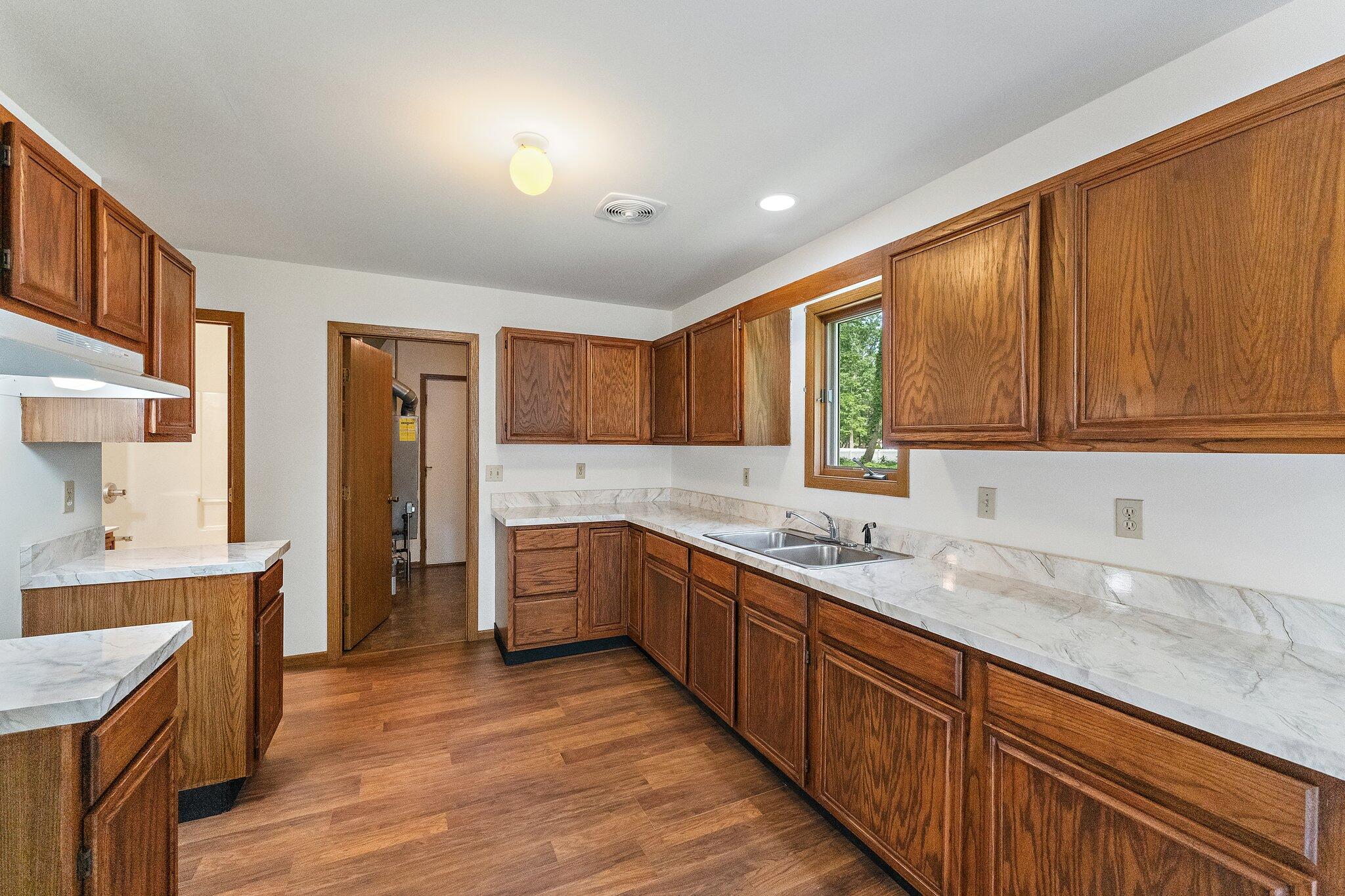 402 Alice Street Kouts, IN 46347 - Photo 9 of 21 a kitchen with stainless steel appliances granite countertop wooden cabinets a sink and dishwasher a oven with wooden floors