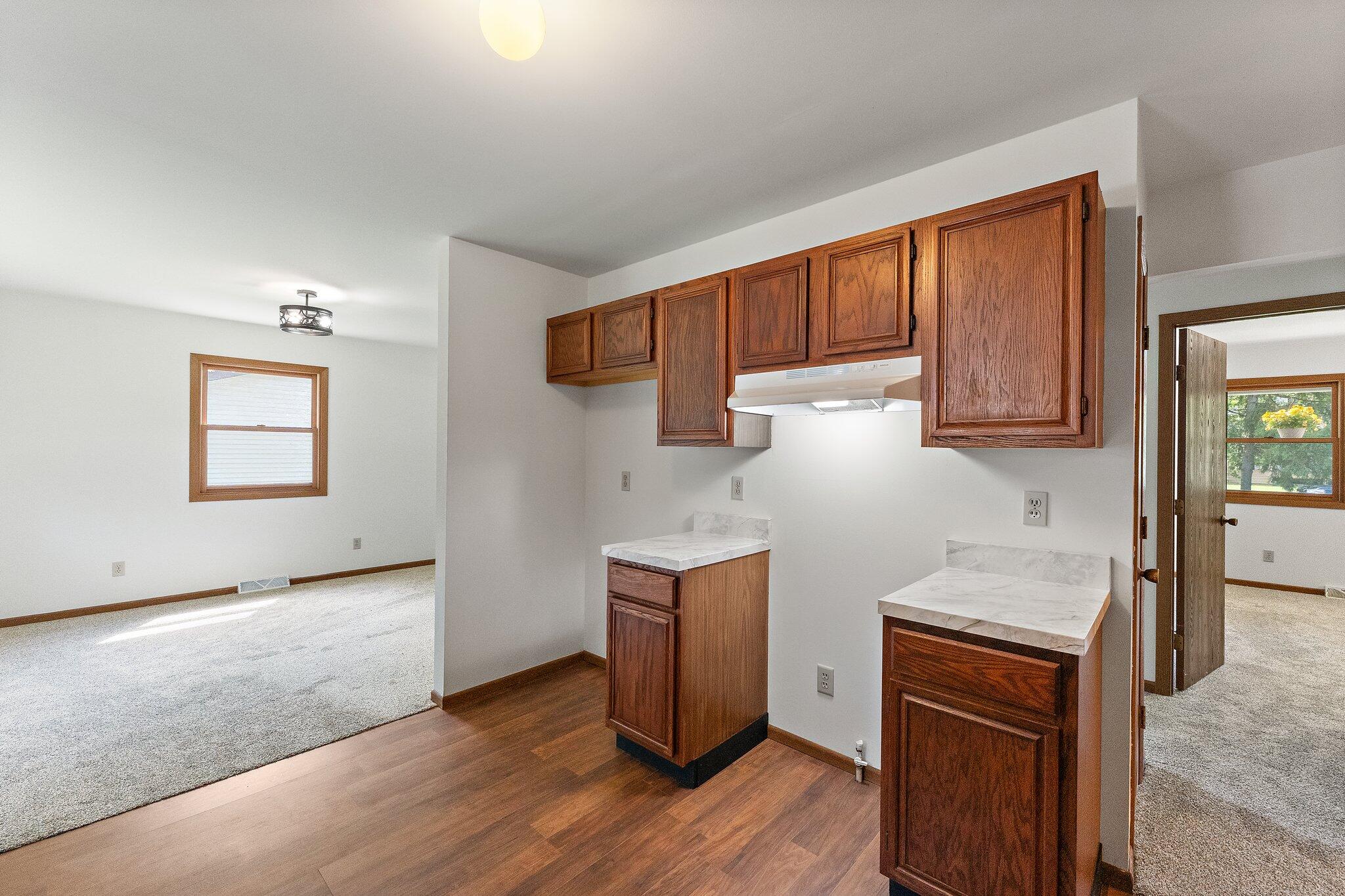 402 Alice Street Kouts, IN 46347 - Photo 10 of 21 a kitchen with granite countertop wooden cabinets and white appliances
