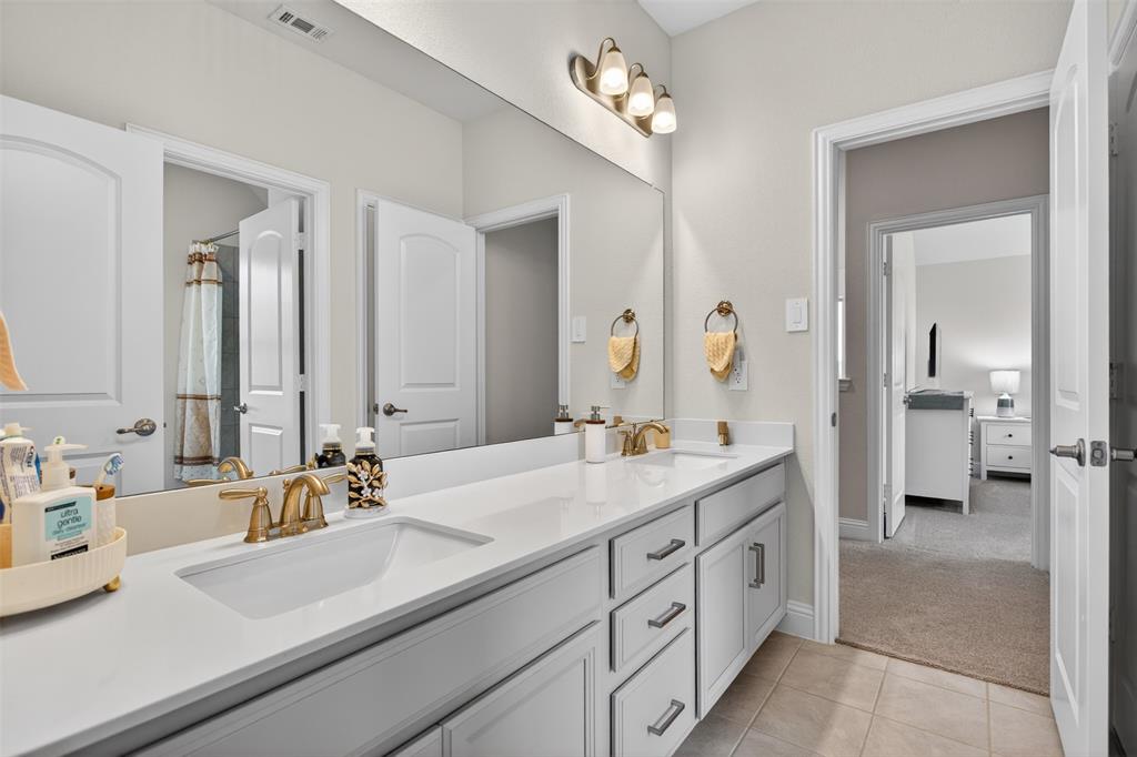 1002 Coppersmith Way Forney, TX 75126 - Photo 21 of 39 a spacious en suite bathroom with double sink and a mirror