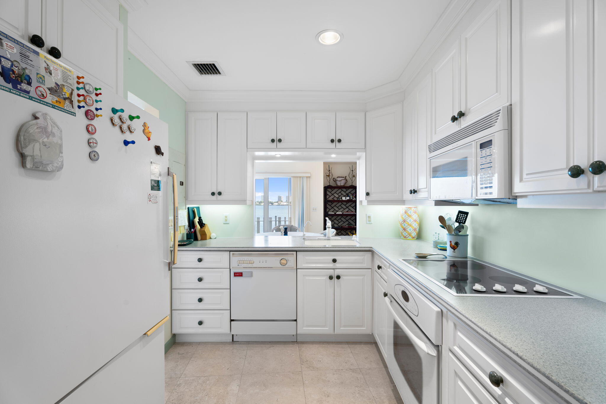371 Wilma Circle, Unit 5 Riviera Beach, FL 33404 - Photo 12 of 43 a kitchen with granite countertop white cabinets and white appliances