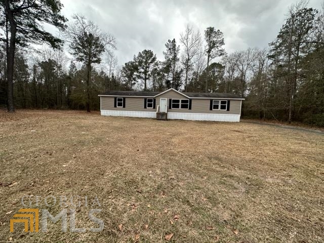1143 Lawrence Church Road Pembroke, GA 31321 - Photo 1 of 1 a front view of a house with a yard and trees