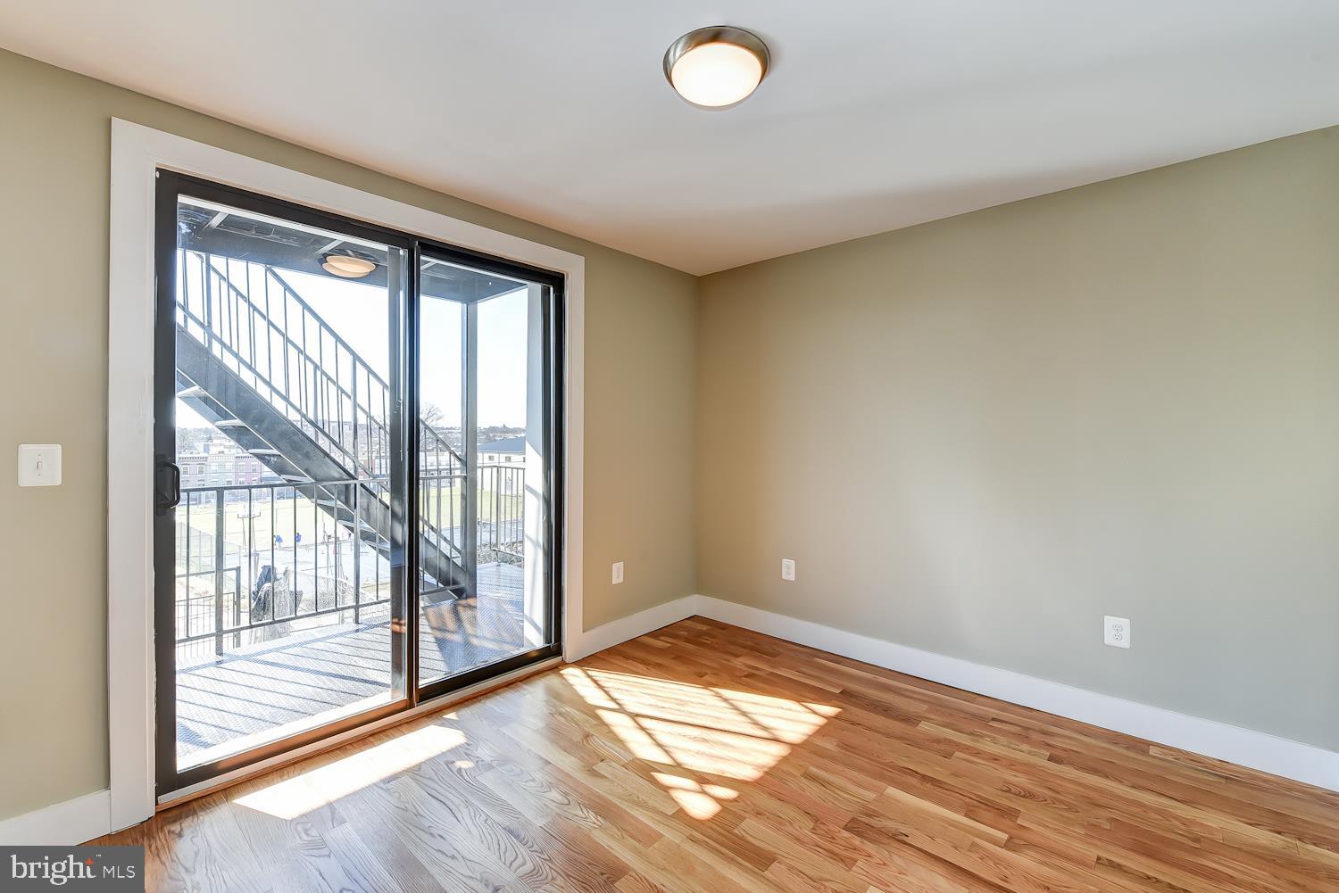 2031 Benning Road Northeast, Unit B Washington, DC 20002 - Photo 13 of 22 an empty room and wooden floor and windows