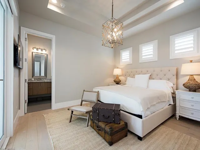 a spacious bedroom with a bed and a chandelier