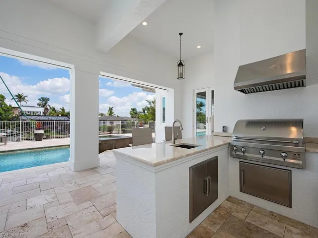 a kitchen with a stove and a view of living room