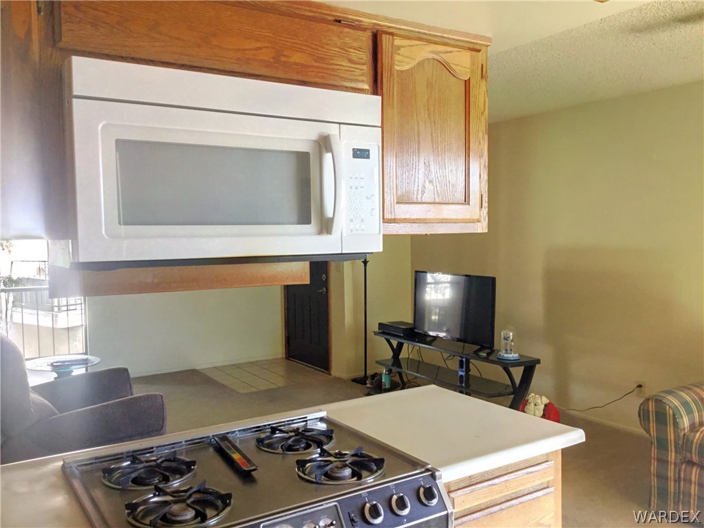 1190 Ramar Road Bullhead City, AZ 86442 - Photo 4 of 32 a kitchen with a stove and a microwave