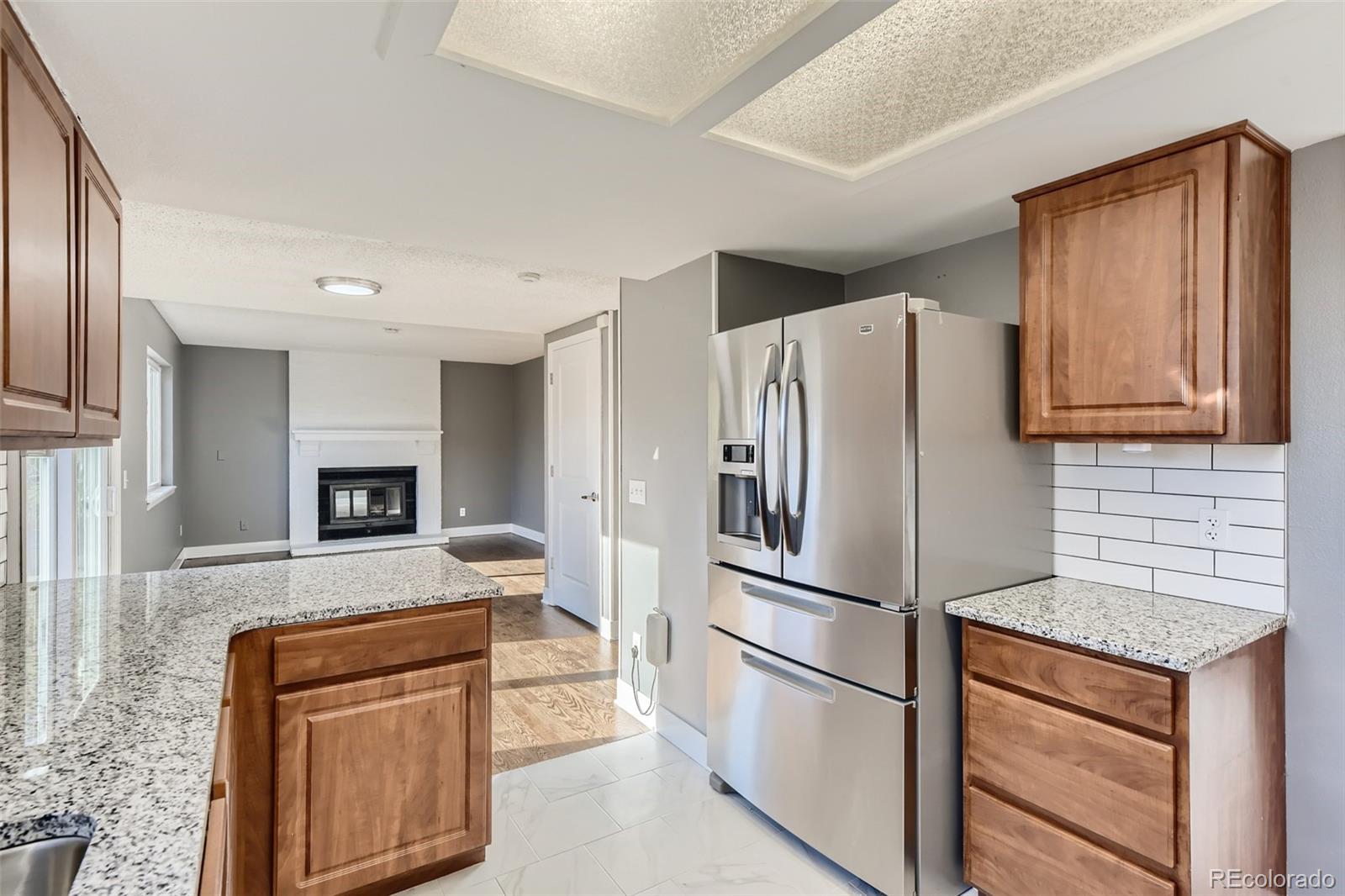 642 Northridge Road Highlands Ranch, CO 80126 - Photo 4 of 31 a kitchen with stainless steel appliances granite countertop a refrigerator and a stove top oven