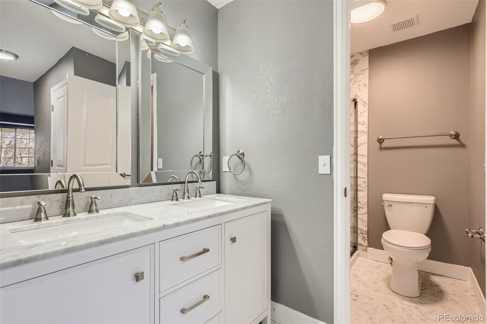 642 Northridge Road Highlands Ranch, CO 80126 - Photo 7 of 31 a bathroom with a granite countertop sink a toilet and a mirror