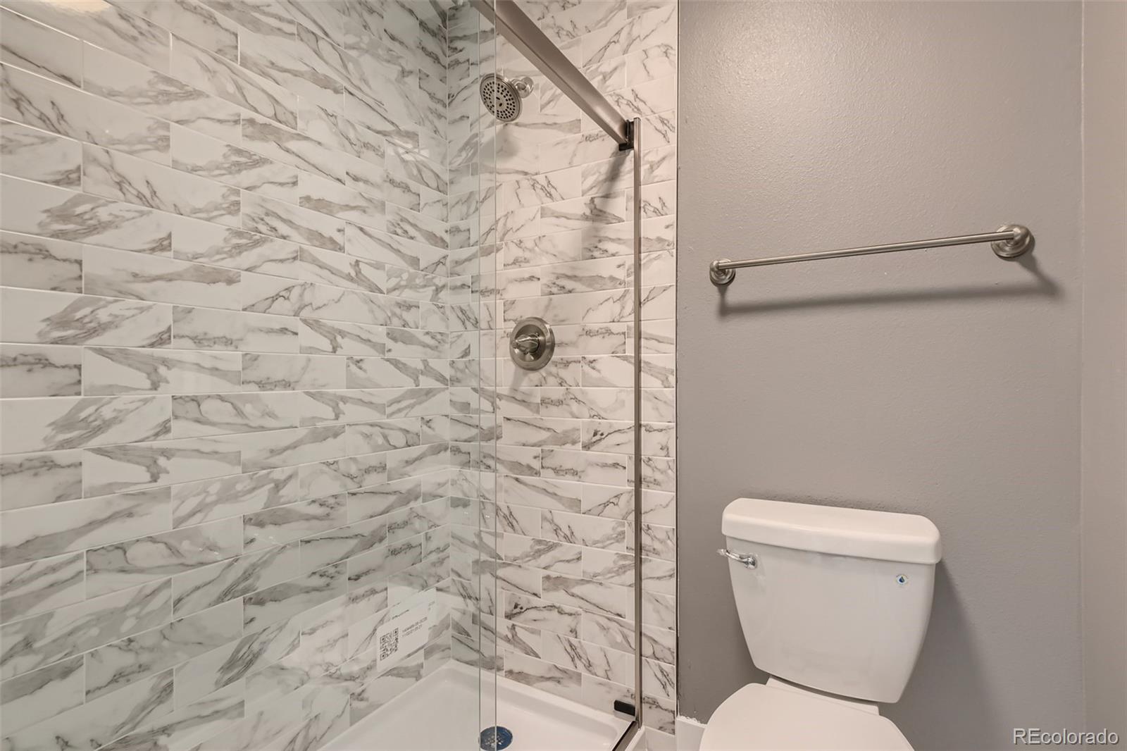 642 Northridge Road Highlands Ranch, CO 80126 - Photo 8 of 31 a white toilet sitting next to a shower curtain