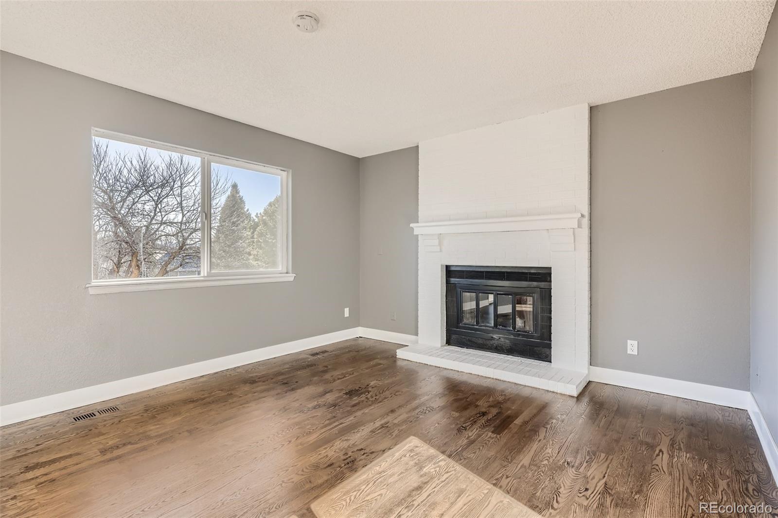 642 Northridge Road Highlands Ranch, CO 80126 - Photo 9 of 31 a view of an empty room with window and fire place