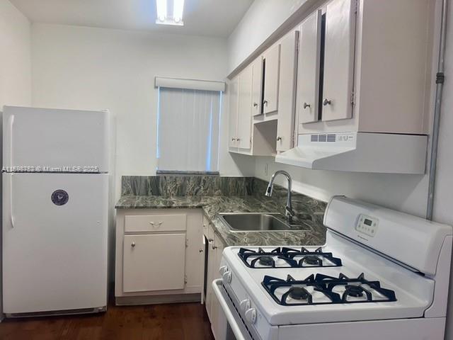 4250 Southwest 67th Avenue, Unit 49 Miami, FL 33155 - Photo 4 of 11 a white kitchen with a stove and a refrigerator