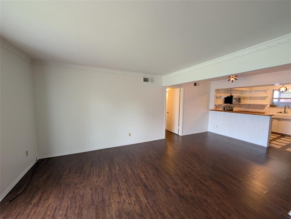 4715 Skillman Street, Unit A Dallas, TX 75206 - Photo 4 of 28 Open concept living area featuring wood-finish flooring, white walls, and decorative crown molding