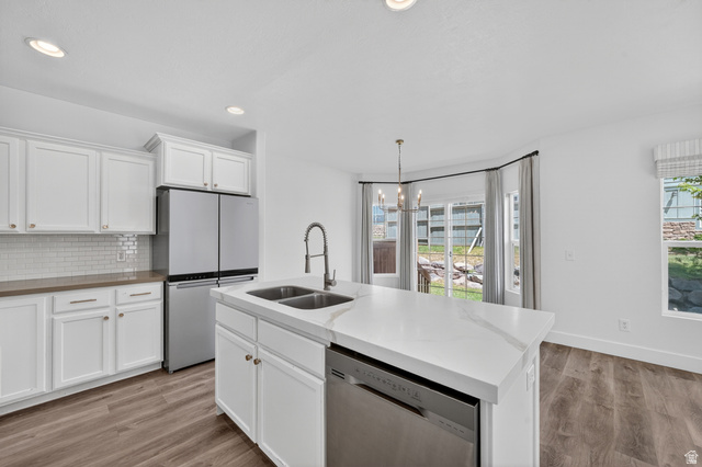 14771 Haddington Road Draper, UT 84020 - Photo 13 of 44 Modern kitchen featuring white cabinetry, stainless steel appliances, and wood-finish flooring