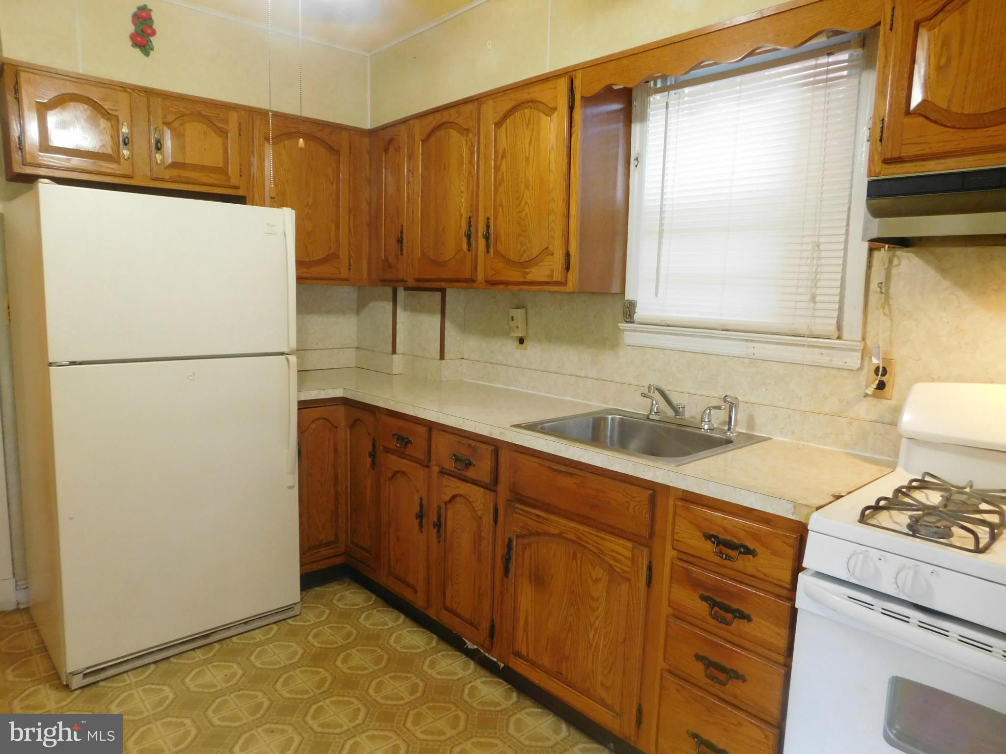 3810 Flowerton Road Baltimore, MD 21229 - Photo 5 of 20 a kitchen with sink cabinets and white appliances