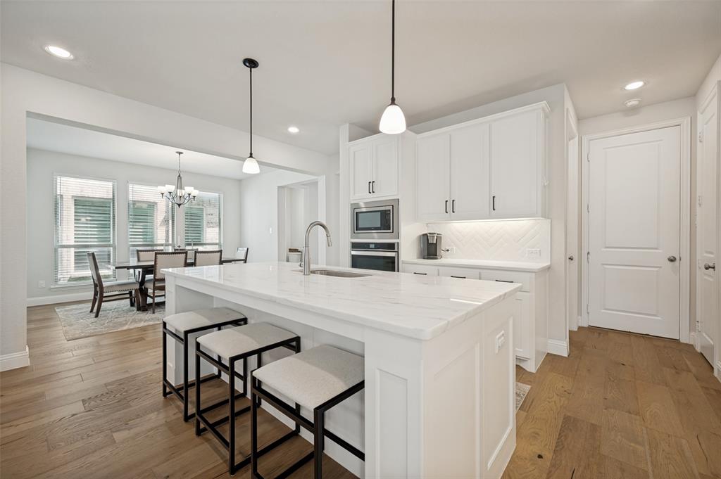 8440 Colburn The Colony, TX 75056 - Photo 4 of 34 Wide plank wood floors and a crisp white palette create a light, airy feel, while the open-concept layout makes this space ideal for both everyday living and entertaining.