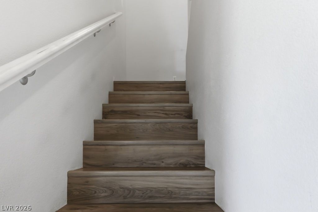 754 Solitude Point Avenue Henderson, NV 89012 - Photo 21 of 38 Natural wood-look steps lead to the upper level, offering a streamlined ascent.