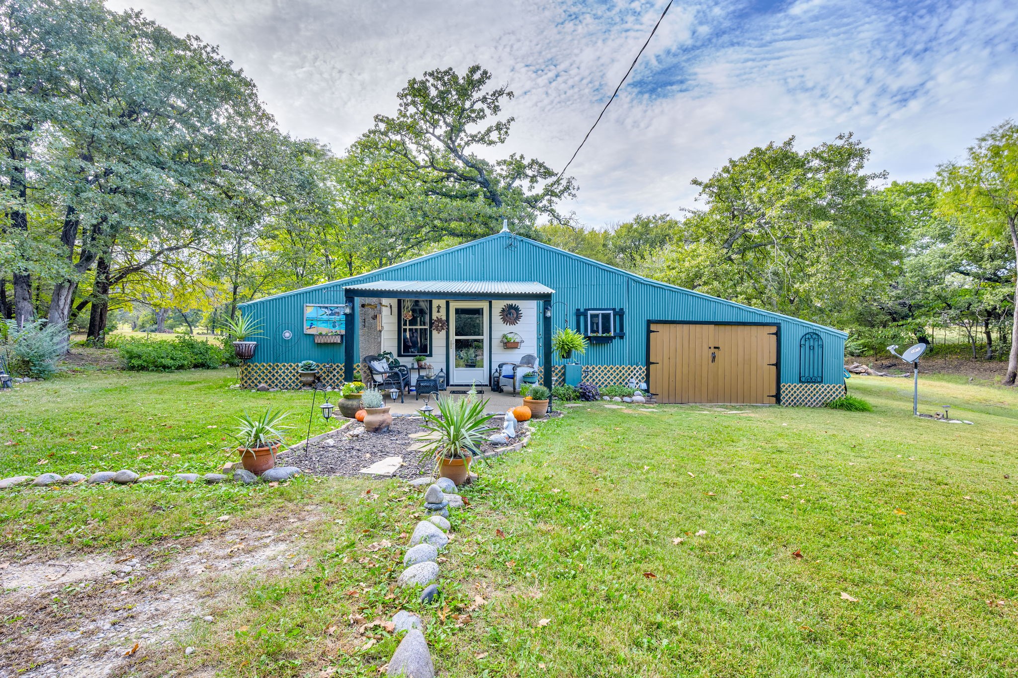 a front view of house with a garden and trees
