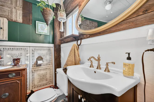 a bathroom with a sink a toilet and a mirror