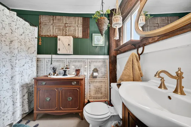 a bathroom with a granite countertop toilet sink and mirror