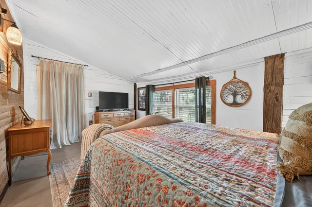 a bed sitting in a spacious bedroom next to a window