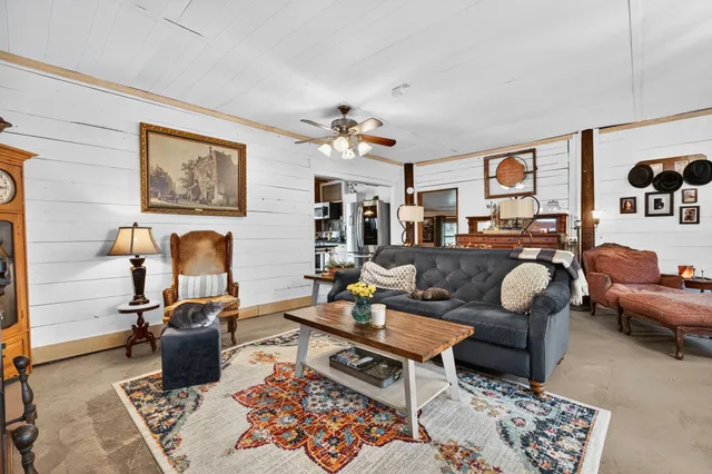 a living room with furniture a rug and a window