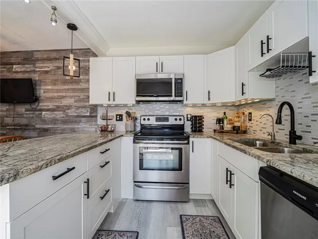 a kitchen with granite countertop a sink and steel appliances