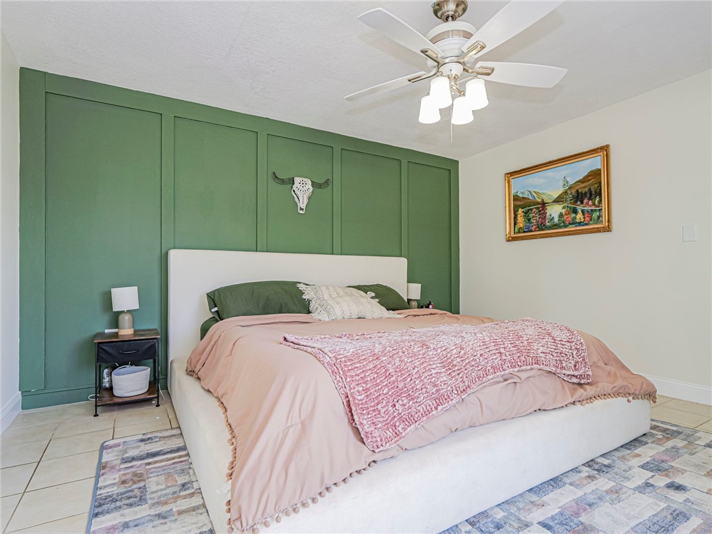 1170 6th Avenue, Unit 8B Vero Beach, FL 32960 - Photo 14 of 24 a bedroom with a large bed and a chandelier