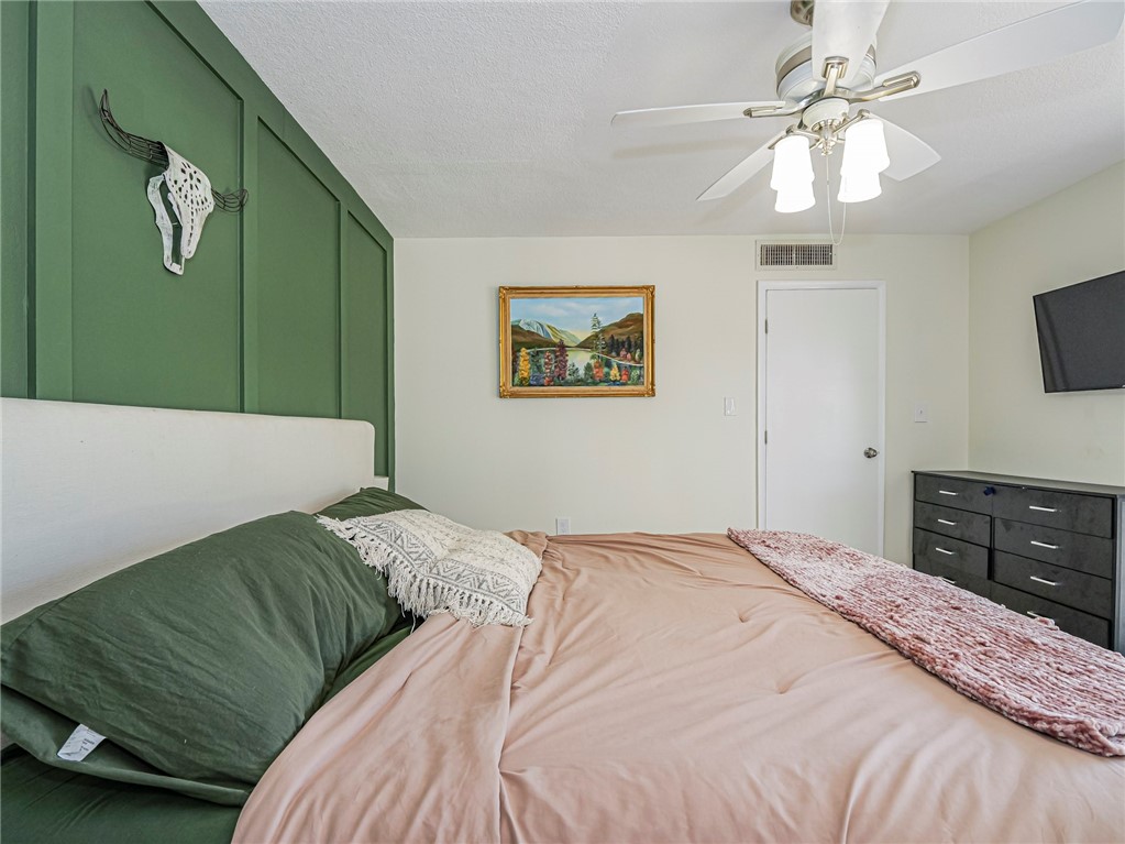 1170 6th Avenue, Unit 8B Vero Beach, FL 32960 - Photo 15 of 24 a bedroom with a bed and a chandelier