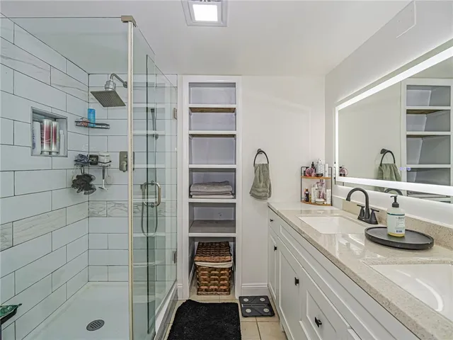 a bathroom with a double vanity sink a toilet and shower