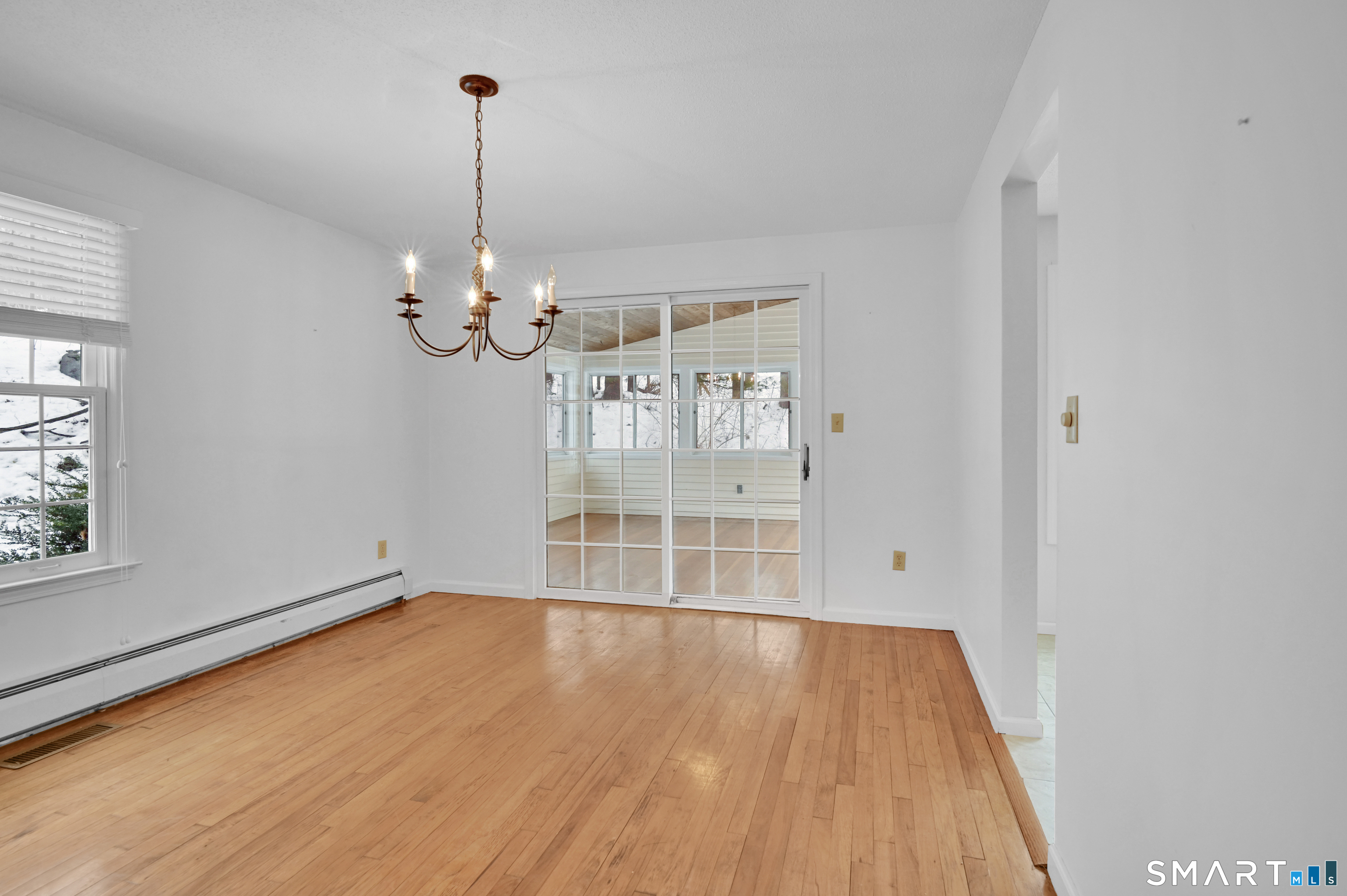 743 Green Hill Road Madison, CT 06443 - Photo 12 of 39 a view of a room with wooden floor chandelier and window