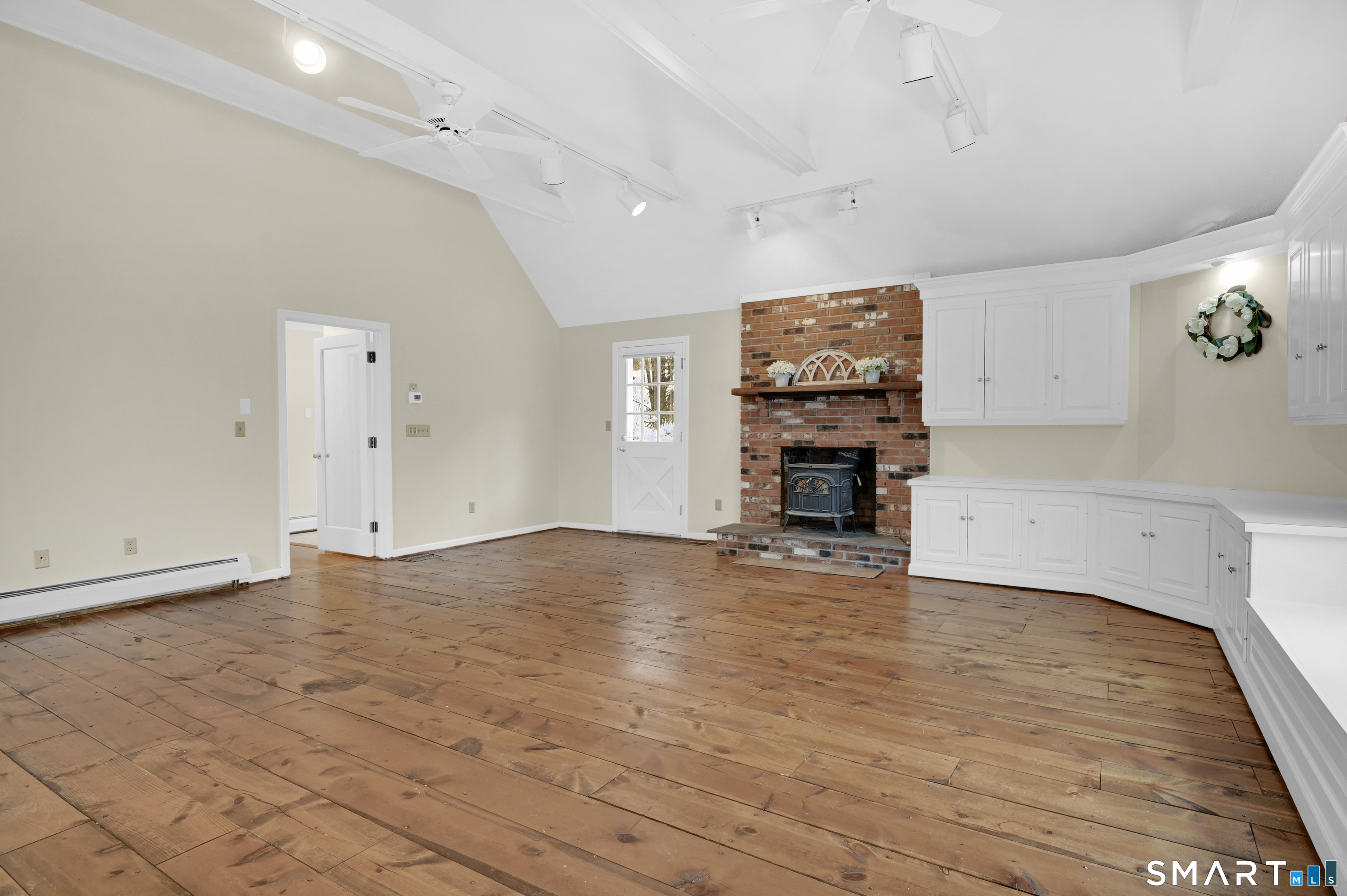 743 Green Hill Road Madison, CT 06443 - Photo 23 of 39 an empty room with wooden floor and fireplace