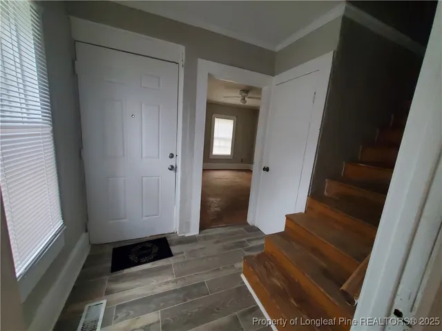 a view of front door with wooden floor and stairs