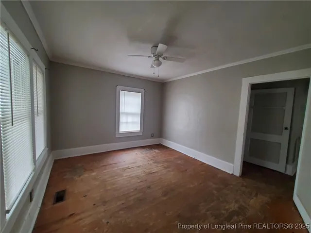 an empty room with windows and cabinet