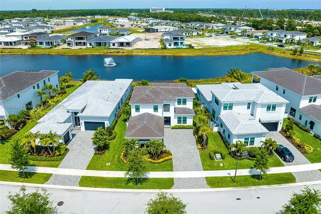 an aerial view of residential houses with outdoor space and ocean view
