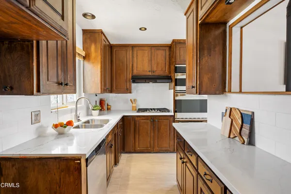 a kitchen with stainless steel appliances granite countertop a sink stove and cabinets