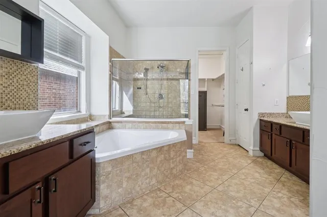 a spacious bathroom with a granite countertop tub sink and a shower
