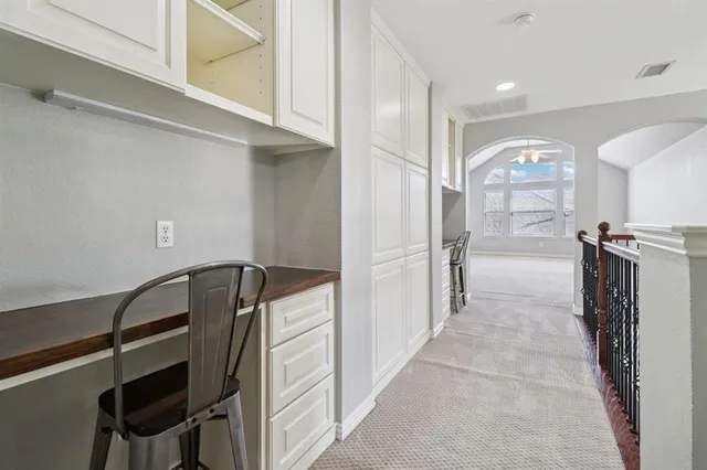 a view of a hallway with wooden cabinets