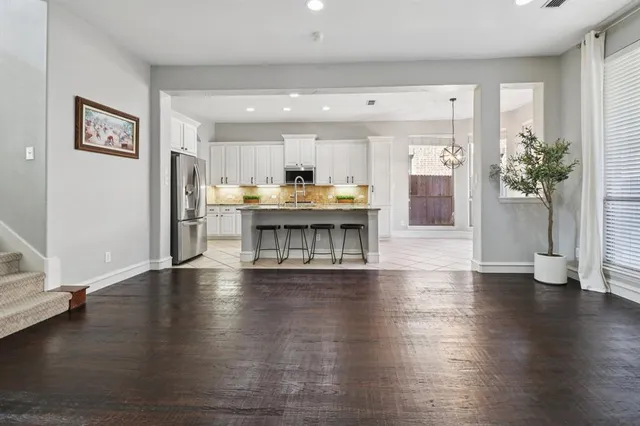 a view of a kitchen with dining table stainless steel appliances and wooden floor