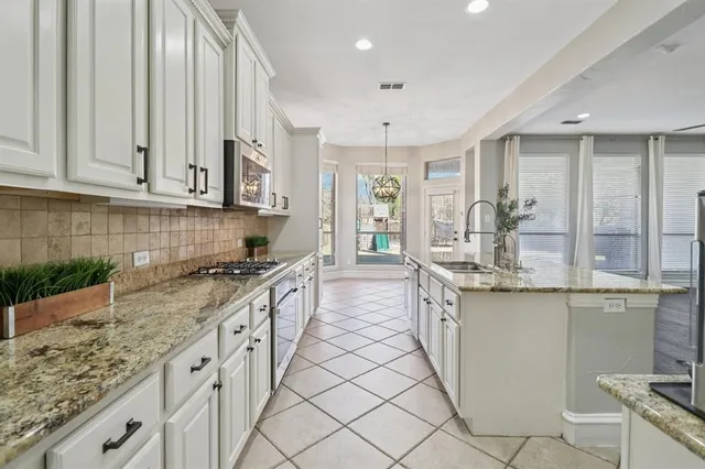 a kitchen with granite countertop white cabinets and white appliances