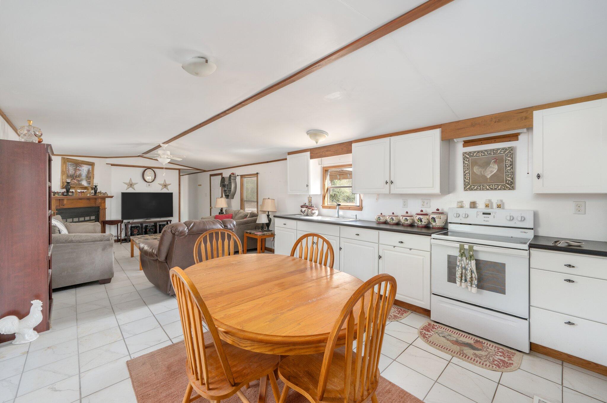 4507 Rainbird Rise Road Crestview, FL 32539 - Photo 13 of 33 a kitchen with stainless steel appliances kitchen island granite countertop a table chairs in it and white cabinets