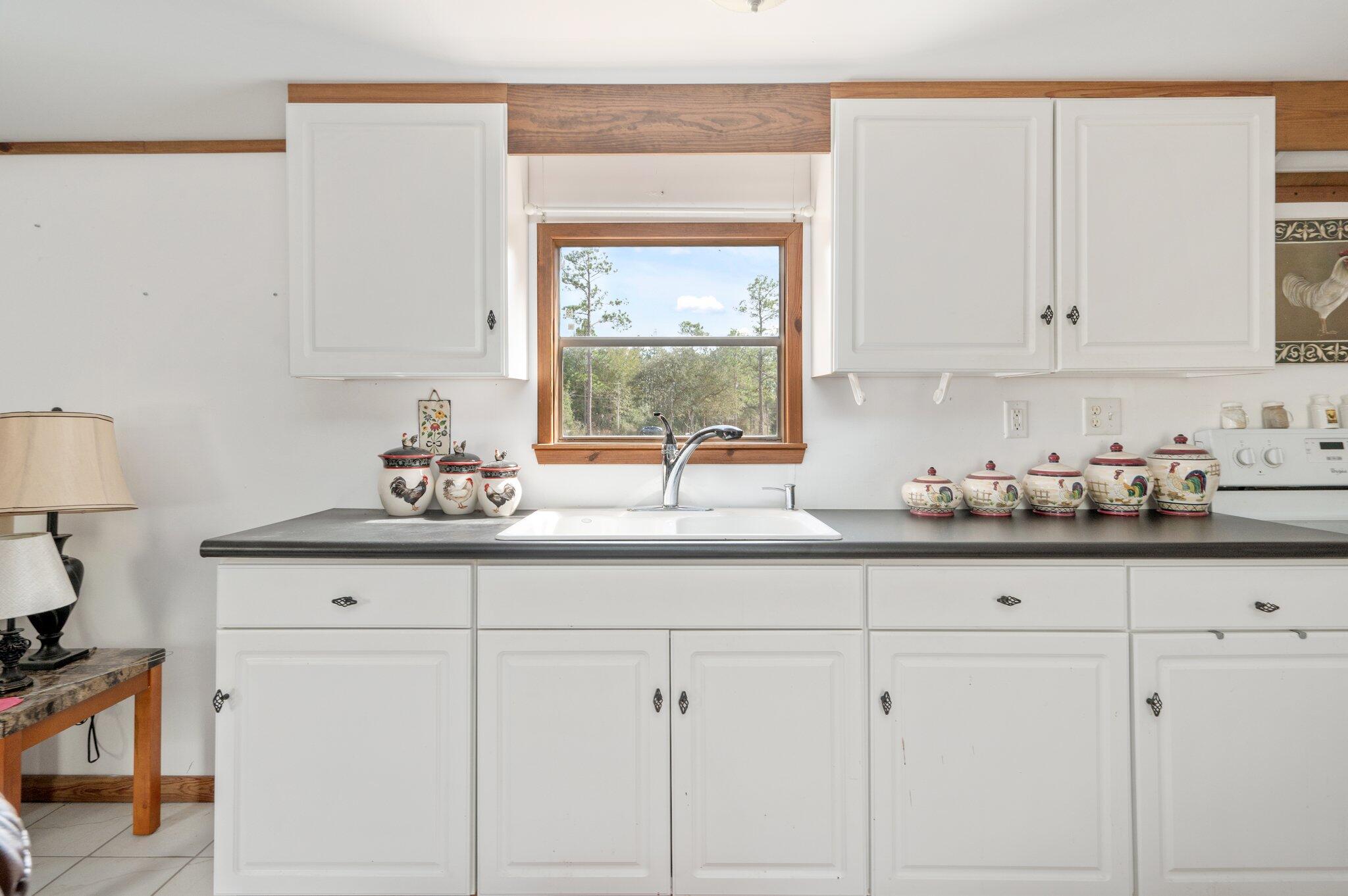 4507 Rainbird Rise Road Crestview, FL 32539 - Photo 10 of 33 a kitchen with granite countertop white cabinets and white appliances