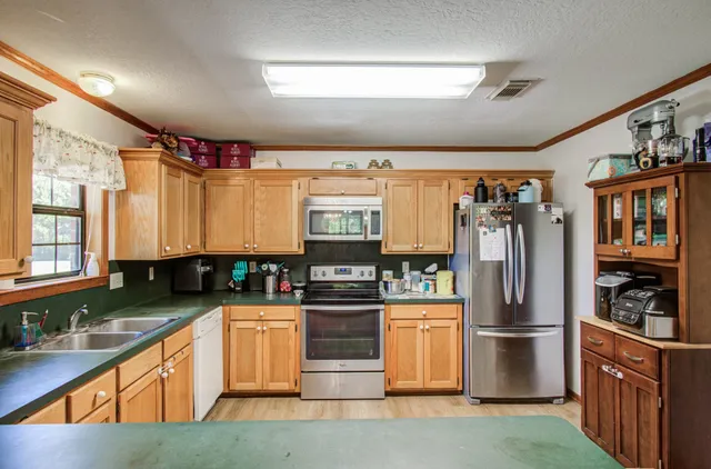 a kitchen with stainless steel appliances granite countertop a refrigerator and a stove top oven