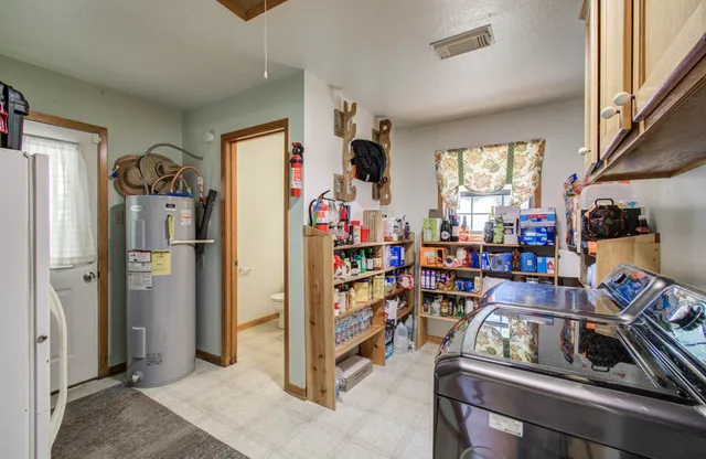 a view of a kitchen with fridge and workspace