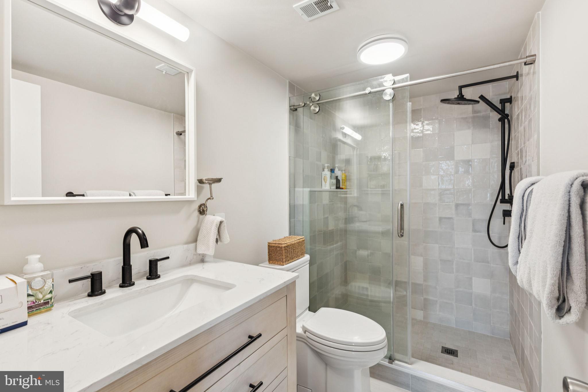 765 South 2nd Street, Unit G Philadelphia, PA 19147 - Photo 25 of 31 a bathroom with a shower sink vanity mirror and toilet