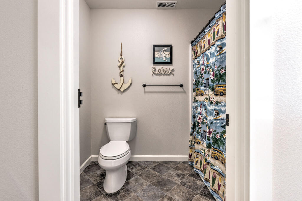 344 Northwest Saddle Ridge Loop Prineville, OR 97754 - Photo 58 of 64 a bathroom with a toilet and a shower curtain