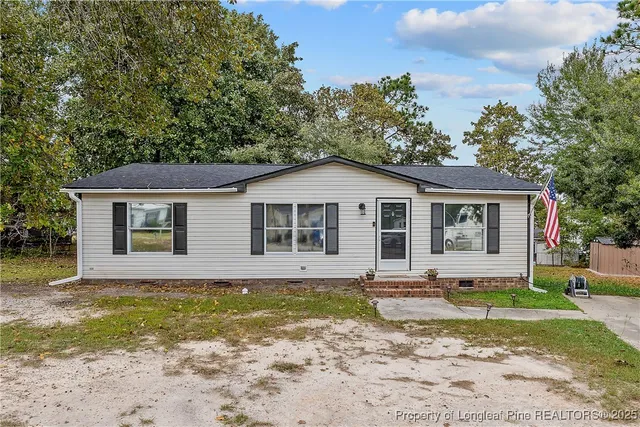 a front view of house with backyard and trees