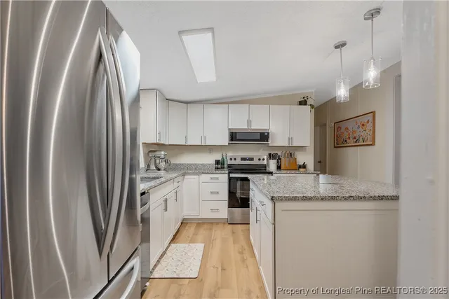 a kitchen with stainless steel appliances granite countertop a refrigerator sink and cabinets