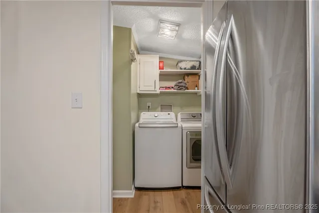 a utility room with wooden floor washer and dryer