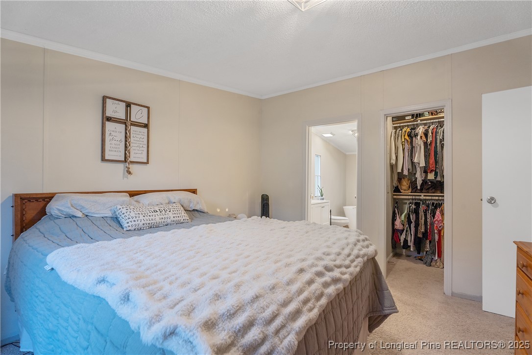 54 West Tryon Court Spring Lake, NC 28390 - Photo 19 of 43 a bedroom with a bed and a walk in closet