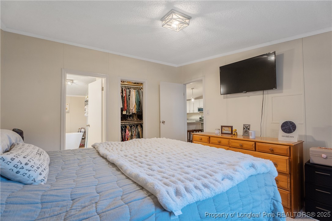 54 West Tryon Court Spring Lake, NC 28390 - Photo 20 of 43 a bedroom with a bed and a flat screen tv