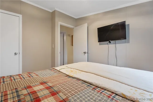 a bedroom with a flat screen tv and a lamp